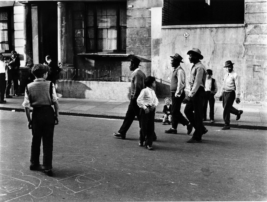 Roger Mayne, A group of black men walking along Southam Street, W10, 1956