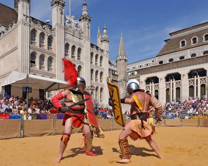 Two Roman-style gladiators fight outside the Guildhall.