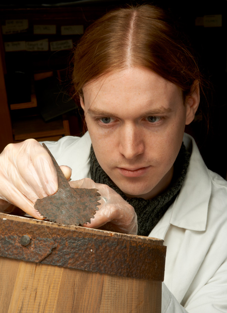 Archaeologist Owen Humphries holds a Roman tool known as a croze, used in barrel-making.