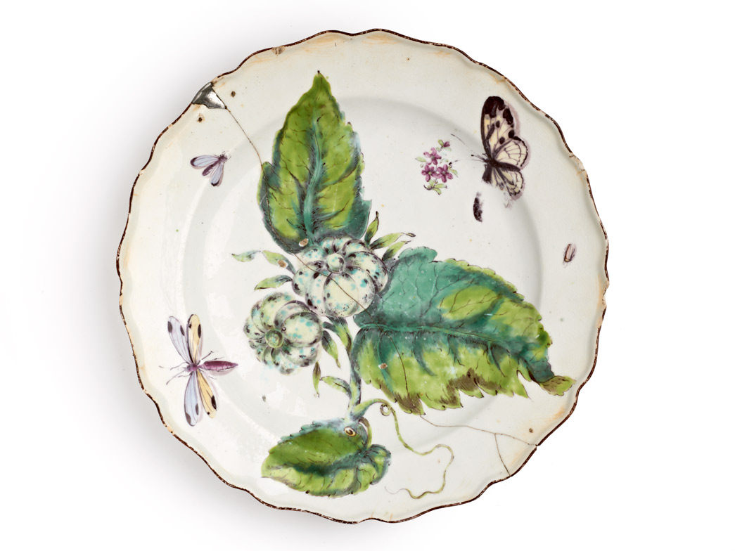 Plate, decorated in 'Hans Sloane' botanical style with enamelled flowers, ladybird, dragonfly and a chocolate line rim. Marked on the base with an iron red anchor over '15', and repaired with rivets. 
