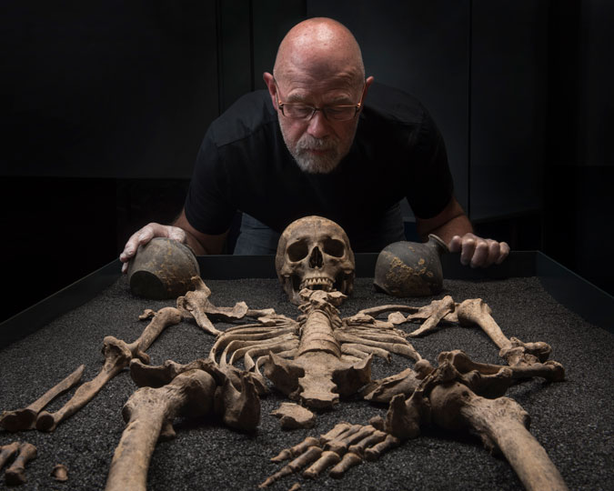 Cliff Thomas installs a skeleton in the Roman Dead exhibition at the Museum of London.