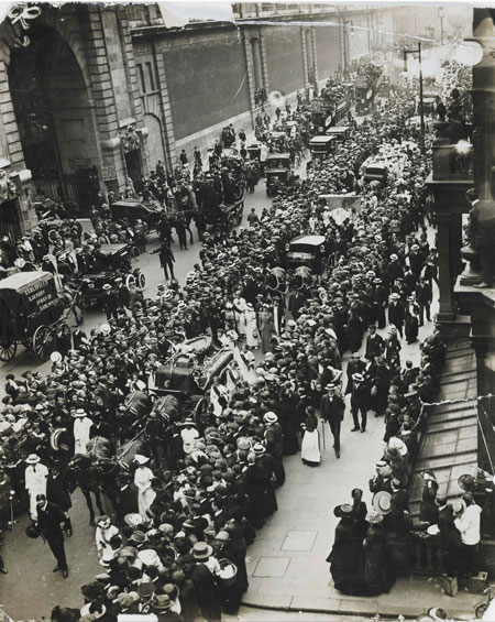 An aerial view of the funeral procession of Emily Wilding Davison approaching Victoria on the 14 June 1913. On 4 June 1913 the suffragette ran onto the Derby race course in an attempt to stop the King's horse. Seriously injured, she never regained consciousness and died four days later. The funeral procession, organized by Grace Roe, made its way in London to St. George's, Hart Street (now New Oxford Street) and Bloomsbury. After a funeral service at St George's, Bloomsbury, the coffin was transported to King's Cross station and on by train to the Davison family home of Morpeth, Northumberland.
