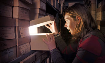 A young woman explores the archive and finds new treasures. (c) Museum of London, Picturechase no 009553.