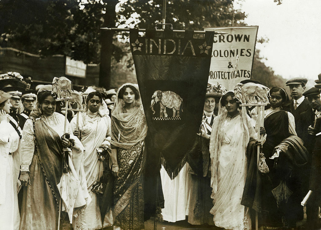Indian suffragettes on the Women's Coronation Procession of 17 June 1911. The small Indian contingent was organised by Mrs Jane Fisher Unwin (the daughter of Richard Cobden). She and other representatives of the WSPU contacted Indian women living in the UK in the weeks leading up to the procession, organised the decorations and the collection of subscriptions for the elephant banner that cost between £4 & £5. The India procession was part of the 'Imperial Contingent' and intended to show the strength of support for women's suffrage throughout the Empire. On the far left of the image can be seen Lolita Roy who had moved from India to Hammersmith, London with her children in 1901. Lolita, a supporter of female suffrage in India became President of the London Indian Union Society. It is possible the young women also seen in the image were Lolita's daughters. 
