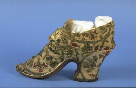 These women’s shoes from around 1720-50 have been made from re-used materials.  The embroidered sections have come from fabric dating to the 1620s (possibly old shoes) and the various elements have been tailored to reflect contemporary fashions.  Off-cuts of white kid form the ill-fitting and slightly miss-matched linings.
