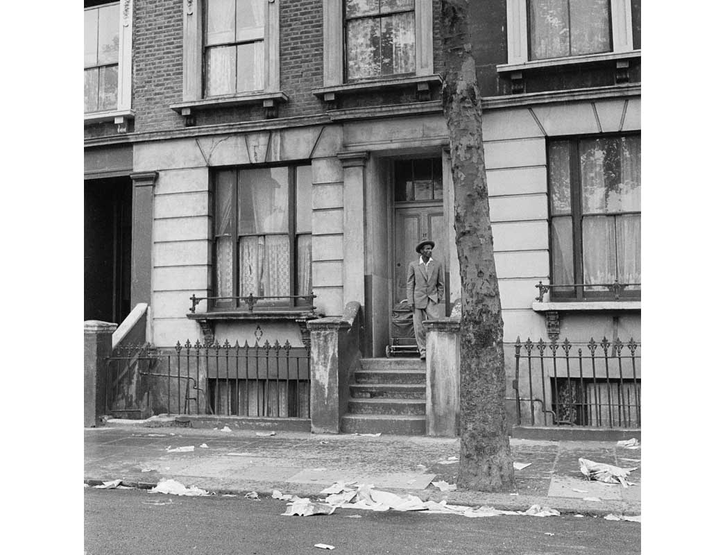 A man on the doorstop of terraced house, Kensington.