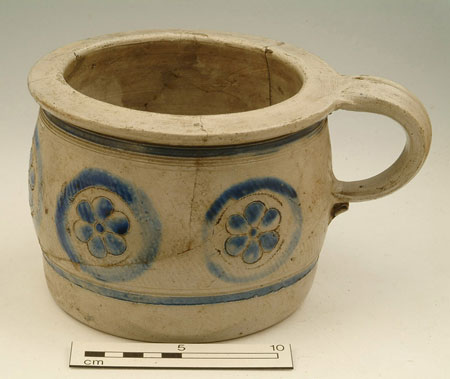 Westerwald stoneware chamber pot (type 2) with incised rings, and flowers with incised outline and painted blue. Found 1929, from bottom of old cess pool, site of public baths.