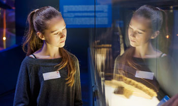 A girl viewing an object during a supplementary schools visit to the Museum of London.