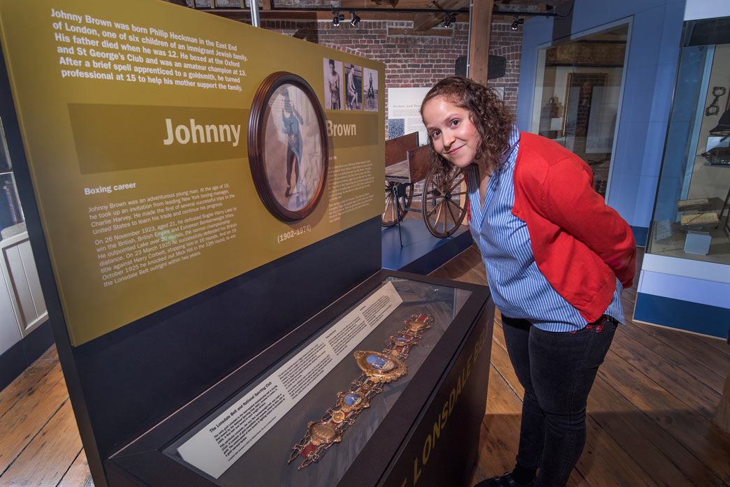 Lauren Johnson of the Jewish Museum stands next to Johnny Brown's Lonsdale Belt.