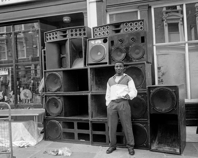 A sound system photographed with a young man standing next to it at the Notting Hill Carnival.
