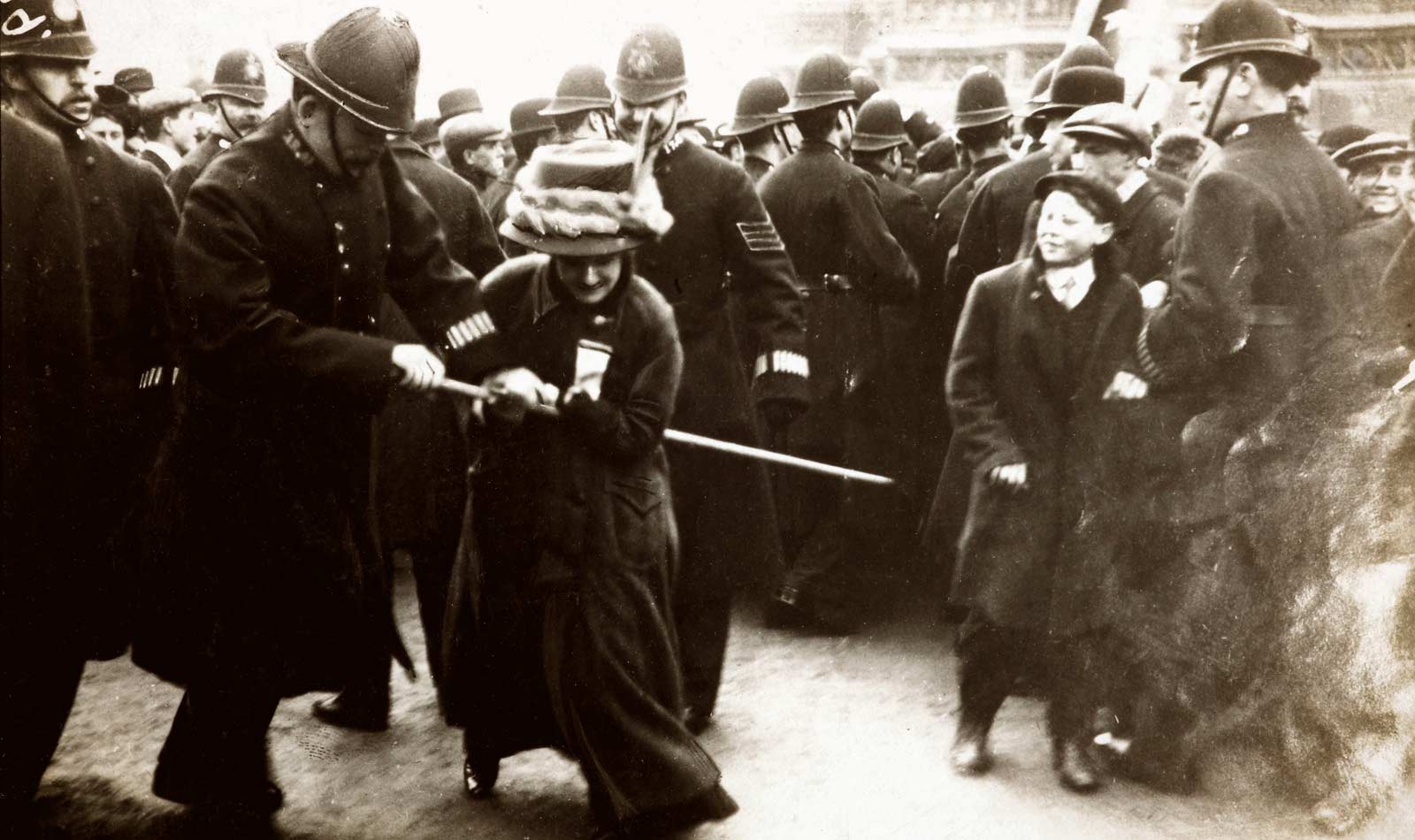 A Suffragette struggling with a policeman on Black Friday 18 November 1910. Furious suffragettes marched on the House of Commons in response to delays to the Conciliation Bill. The resulting riot ended in the arrest of 115 women and four men. Many of the protestors suffered violence, intimidation and even acts of indecency at the hands of the police. One suffragette noted 'Several times constables and plain-clothes men who were in the crowds passed their arms round me from the back and clutched hold of my breasts in as public a manner as possible, and men in the crowd followed their example...My skirt was lifted up as high as possible, and the constable attempted to lift me off the ground by raising his knee. This he could not do, so he threw me into the crowd and incited the men to treat me as they wished'.  < ...Read more

