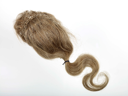 This wig has a linen base and brown-blonde human hair in a ponytail. It is part of a set of male clothes and accessories for a lay figure used and made by artist Louis François Roubiliac.
