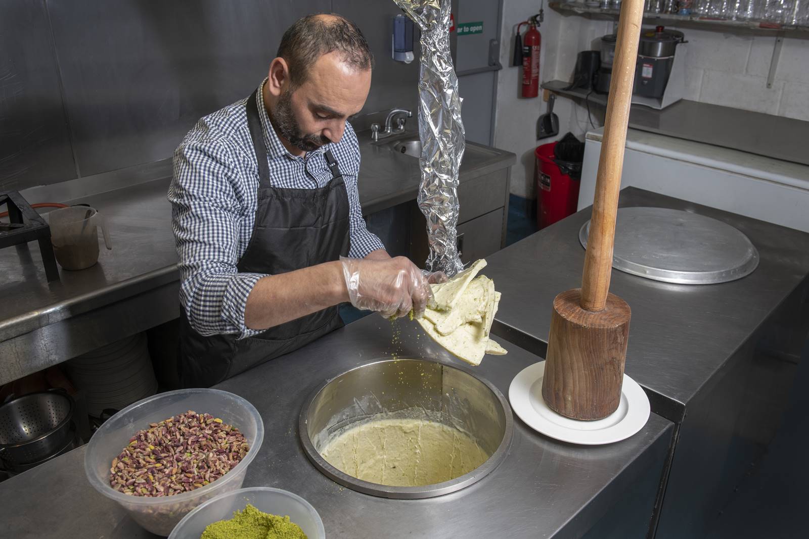How to make Syrian ice cream, booza
Asami cuts out slices of the frozen mixture lined inside the metal containers.