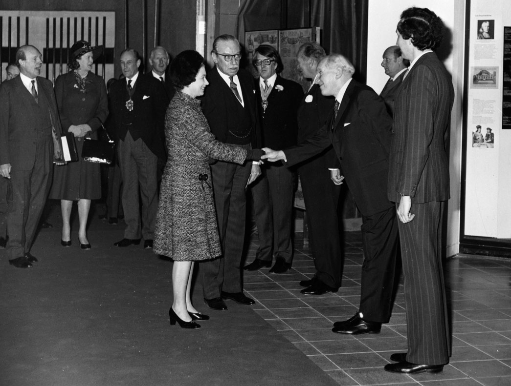 H.M. The Queen is greeted by Mr. Tom Hume , Director of the Museum of London, as she arrives to open the new museum, on Thursday 2nd December. With the Queen is Lord Harcourt, Chairman of the Board of Governors of the Museum of London. Others are L-R Sir Martin Charteris, Private Secretary to the Queen, Mrs Dugdale, Lady in Waiting, the Lord Mayor, Sir Robin Gillett, The City Remembrancer Lord Posonby, Chairman of the GLC Lord Donaldson, Ministers for the Arts, Mr Leslie Whatley, Mr Max Hebditch, Deputy Director, Museum of London.
