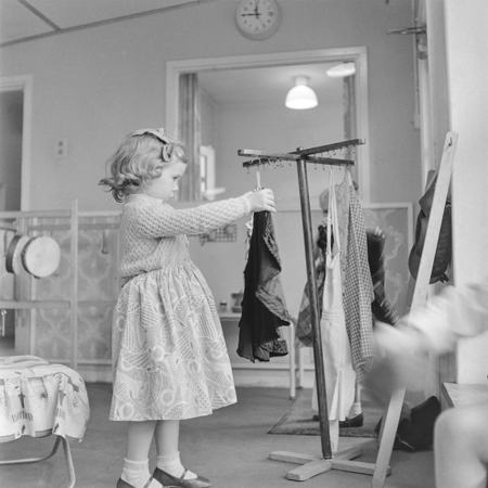 Henry-Grant--A-young-girl-playing-dressing-up-at-Sumner-Nursery-School,-Peckham,-1959.jpg