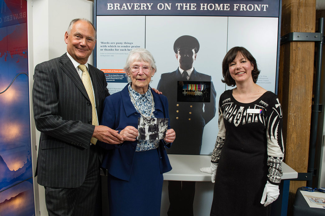 Members of Richard Moore's family stand in front of a display of his medals, with curator Vyki Sparkes.