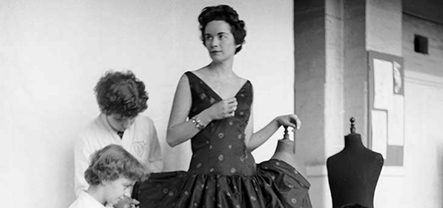 A woman having a dress fitted by tailoring students at Shoreditch College