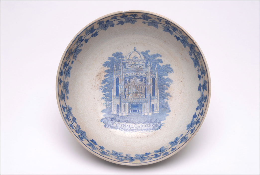 Transfer printed earthenware bowl with ivy leaf decoration and picture of organ and bandstand inscribed 'VAUXHALL GARDENS'. There is a view of Vauxhall gardens pavillion printed inside the bowl.
