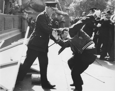 This image shows clashes at a Mosley riot in Trafalgar Square between supporters, protestors and the police, c. 1960. Sir Oswald Mosley was a leader of the British fascist movement. A prominent figure before the Second World War, he stood at the 1959 general election for Kensington North, shortly after the 1958 Notting Hill race riots, and again at the 1966 general election, this time for Shoreditch and Finsbury. However, opposition to fascism was strong in post-war Britain and on both occasions he polled few votes.