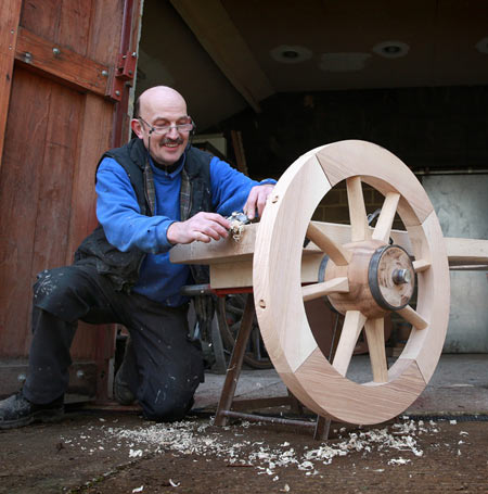 View of Croford's coachbuilders making wooden wheel of the fire engine.