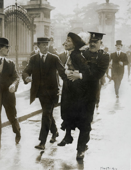 Emmeline Pankhurst being arrested while trying to present a petition to the King at Buckingham Palace, 21 May 1914. As she was being carried past a group of reporters Emmeline called out 'Arrested at the gates of the Palace. Tell the King'.