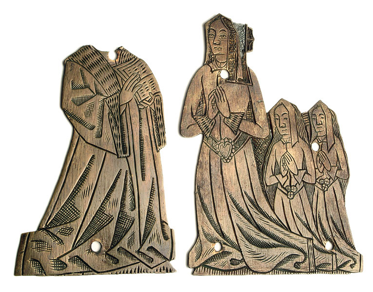 Photograph of two metal plaques depicting a kneeling family. On the left is one depicting Henry Redman, the second is on the right depicting his wife and two daughters.