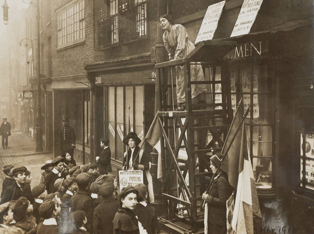 Sylivia Pankhurst addressing a crowd outside the headquarters of the East London Federation of Suffragettes, Old Ford Road, Bow, 1912. (ID no.: NN22843)