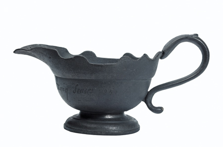 A Pewter sauce boat with a scalloped edge. It is inscribed 'R G Bought on ye Thames at King Stairs 1740'. It was produced to commemorate the Great Frost Fair of 1739 - 1740. There is a touch mark on base X IK, which probably refers to John Kendrick of Cherry Garden Stairs, Rotherhithe.
