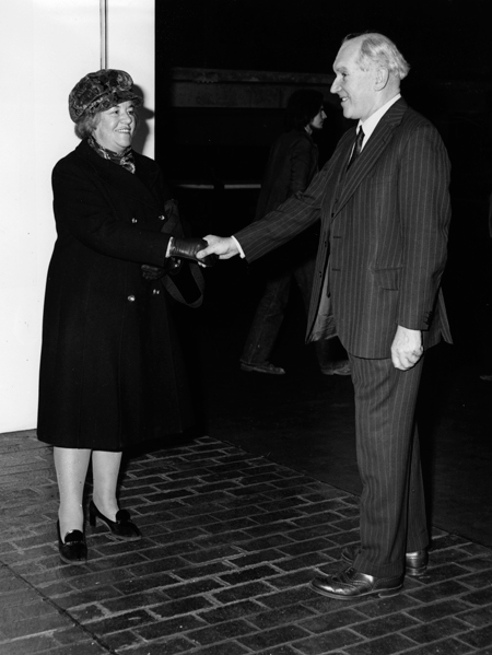 The First public visitor, Miss Blanche Hammond, is greeted by Mr Tom Hume, Director of the Museum of London, who presented her with a model London Bus carrying the Museum's advertsiement now seen on the streets of London