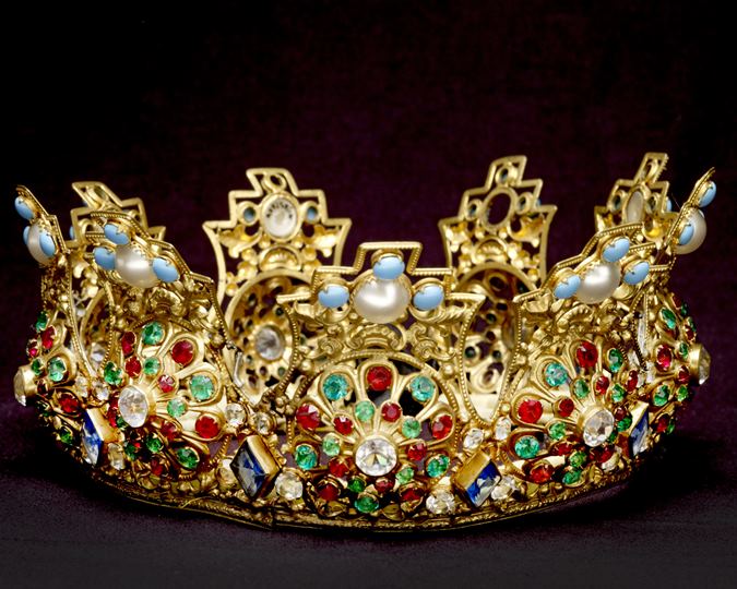 Crown made from gilt metal and set with multicoloured paste stones. There is a padded textile band around the inside. (ID no.: A23255/14)