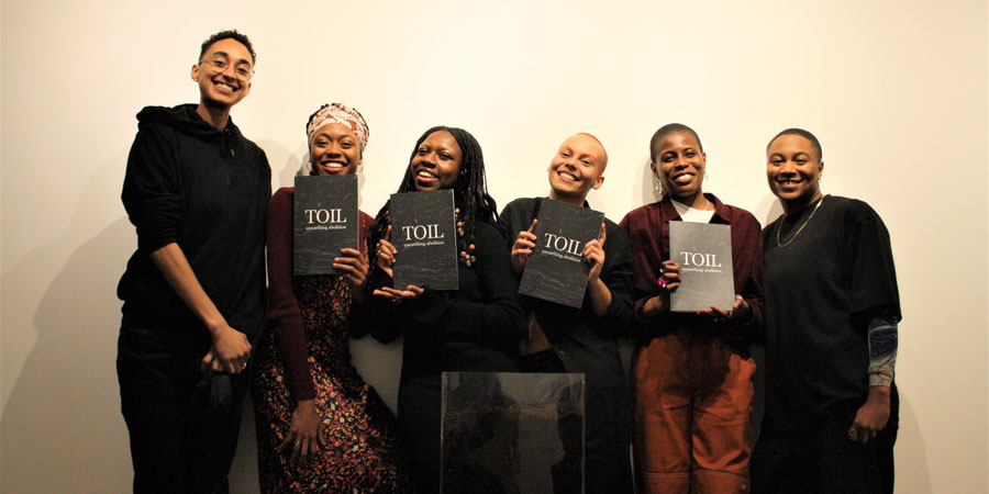 six young people smiling and holding print copies of a publication entitled Toil