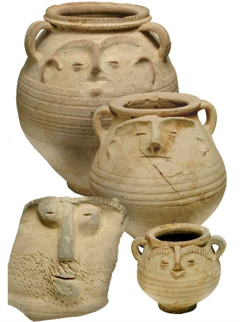 Photo of four clay pots with hand sculpted faces on them with long noses, bushy, wide eyebrows and thin lips.