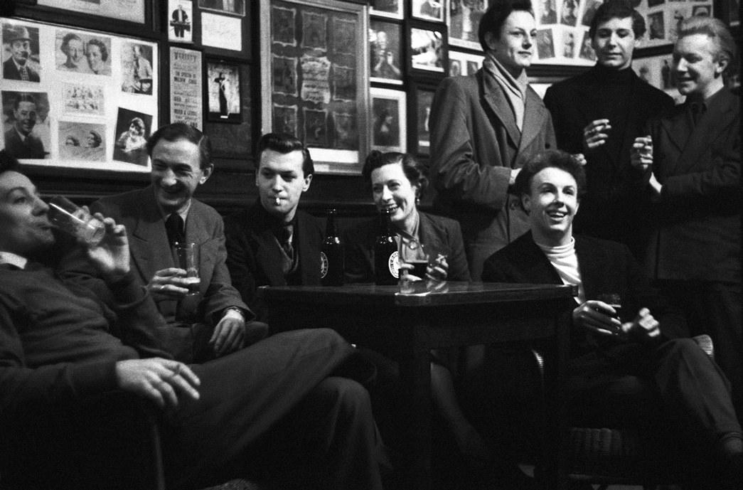 In the bar at the famous Collins' Music Hall in London's Islington. Mrs Hazel Lewis surrounded by cast members of ‘This Was The Army’. (© Alan Vines / Topfoto)
