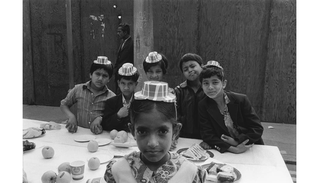 A group of young Asian children pose at a street party wearing union jack hats for the wedding of Prince Charles and Lady Diana Spencer. Paul Trevor
