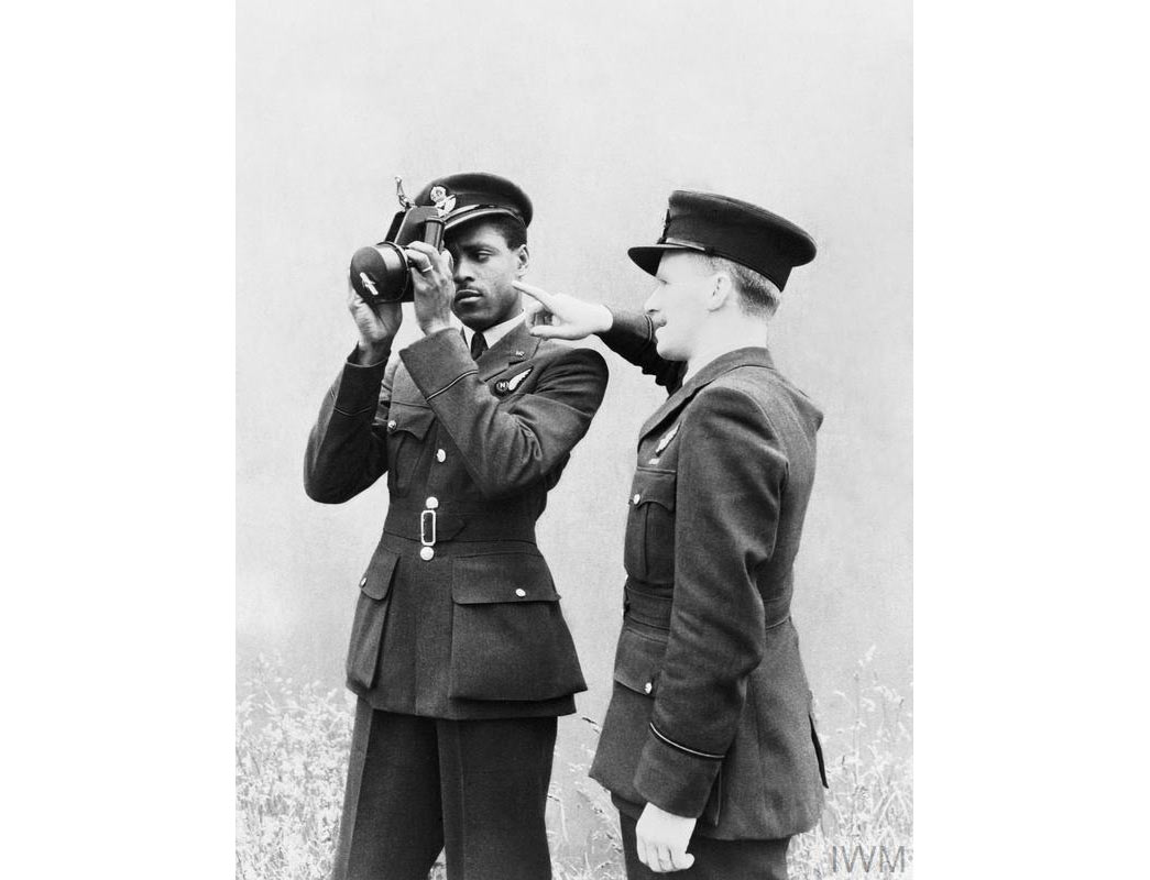 Pilot Officer J H Smythe RAFVR of Sierra Leone, a newly-qualified navigator, being instructed in the use of the sextant by a flying officer instructor at No 11 Operational Training Unit, Westcott, Buckinghamshire, England.