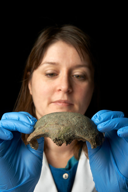An osteologist holds a skull fragment from the River Thames.