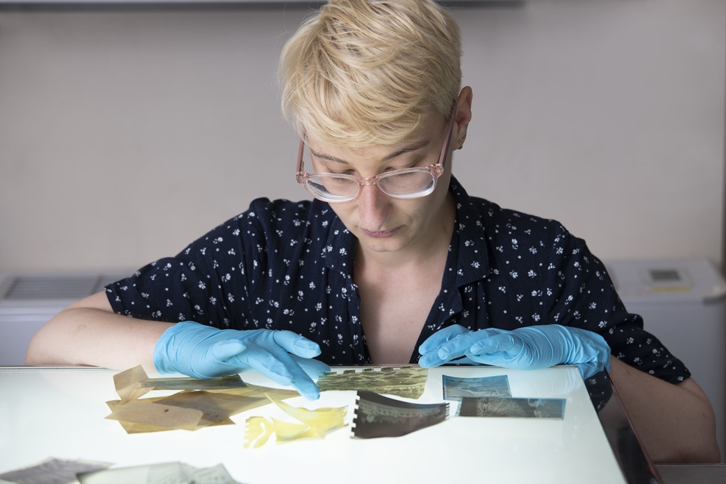 Museum conservator Mathilde Renauld taking a close look at degraded negatives. (©Museum of London)