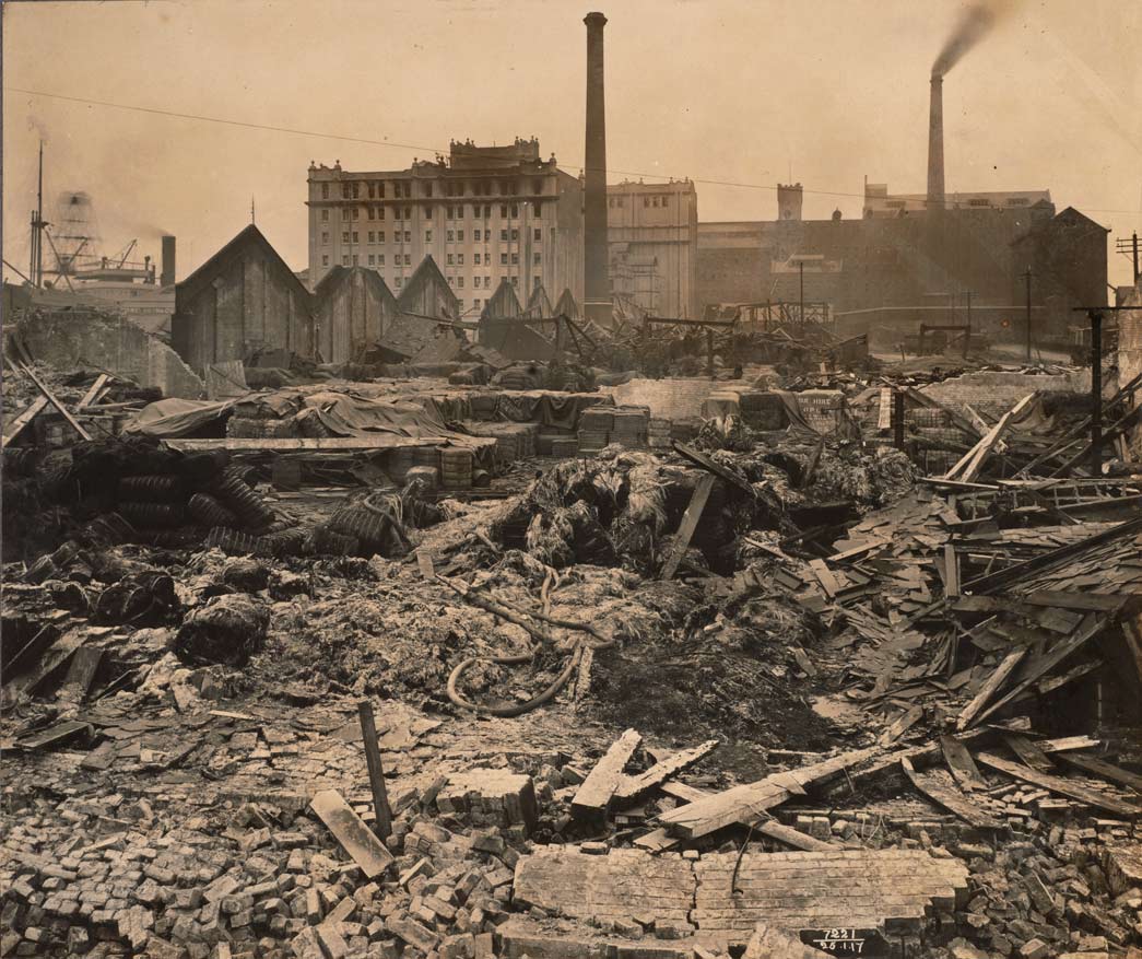 Photograph showing the remains of sheds 7, 9 & 11 at Royal Victoria Dock, following the Silvertown explosion. Taken by John H Avery on 23 January 1917.