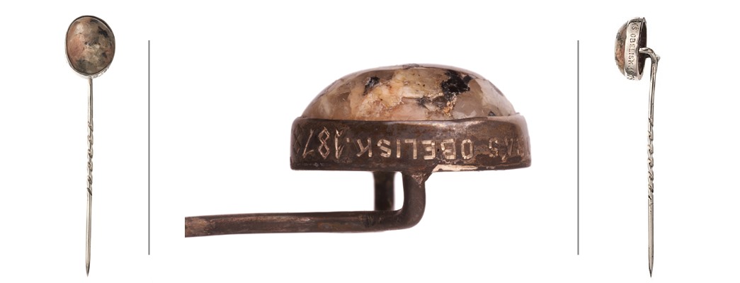A cravat pin with a pink and grey granite at the top, set in silver and with the inscription: “Chip of Cleopatra’s Obelisk, 1878”. (ID no.: 77.87/124)