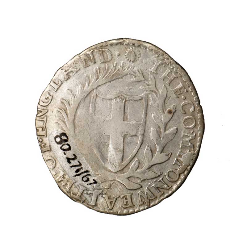 Photo of a Silver sixpence of the Commonwealth, with 'sun' mint mark on obverse, of Tower mint, dated 1653. Obverse: Shield of England, with legend 'COMMONWEALTH. OF. ENGLAND'. 