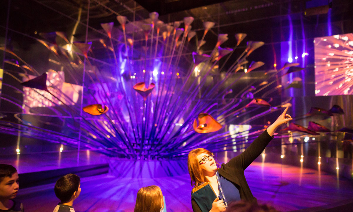 A facilitator shows children the 2012 Olympic Cauldron at the Museum of London.