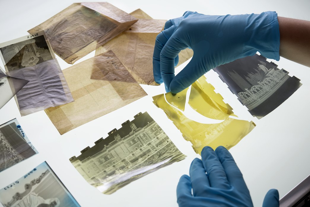Museum conservator Mathilde Renauld analyses the various negatives. The one at the centre is a disintegrated cellulose nitrate negative that has completely yellowed and broken into pieces. (©Museum of London)