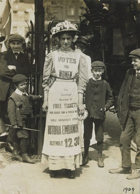 The Suffragette, Vera Wentworth walking along The Strand, London wearing an apron advertising a march, 1909.
