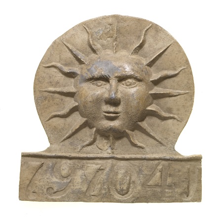 Fire mark depicting the sun. Features insurance policy number ‘797041’.  Fire marks were placed outside buildings to indicate which company insured the property. 