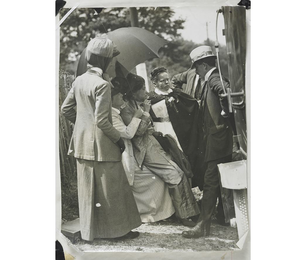 This photo, on display in the People’s City Gallery, shows Emmeline Pankhurst being rearrested on 26 May 1913, whilst recuperating at Smyth’s home in Woking. Shading herself from the heat, Pankhurst is dressed in a grey suit and still weakened by hunger strike is here seen fainting back on the knee of Smyth. (ID no.: 50.82/1400)
