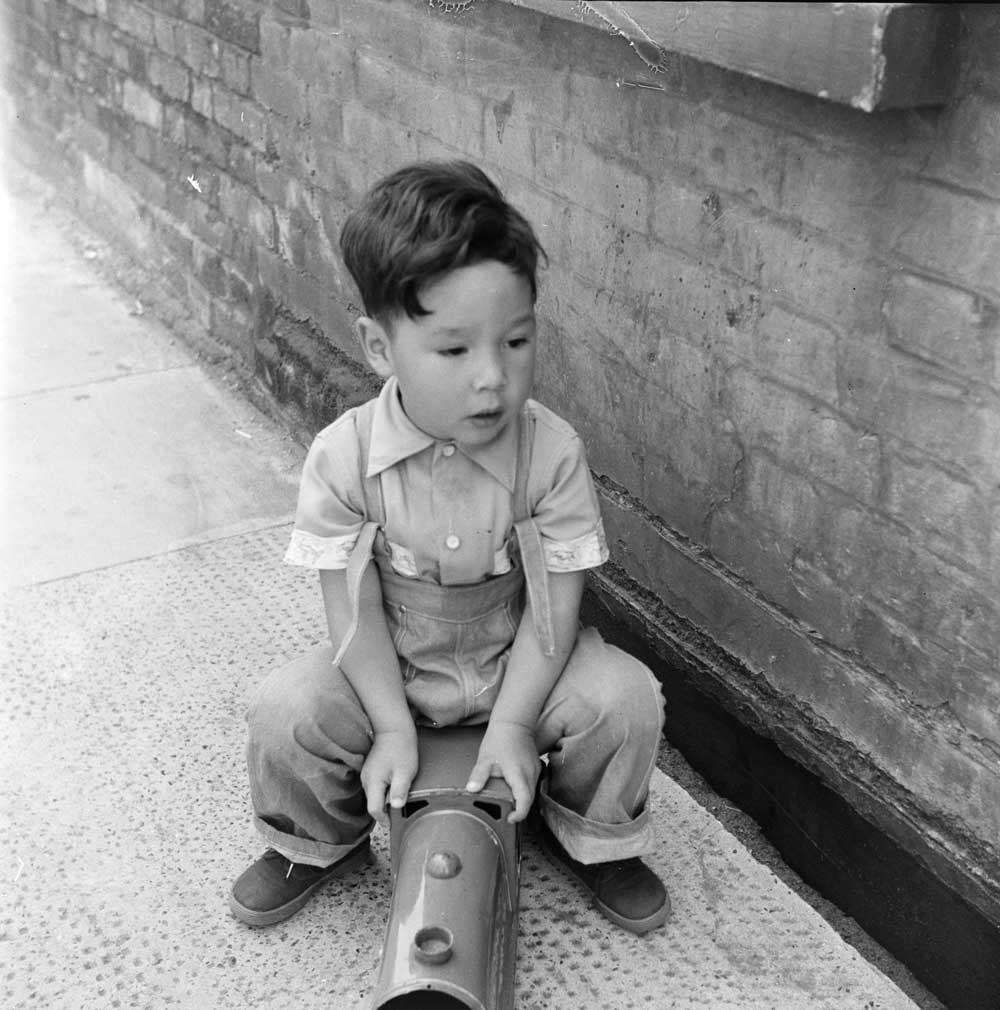 Boy playing with a toy train on a street in Limehouse in the mid 1950s. © Henry Grant Collection/Museum of London 