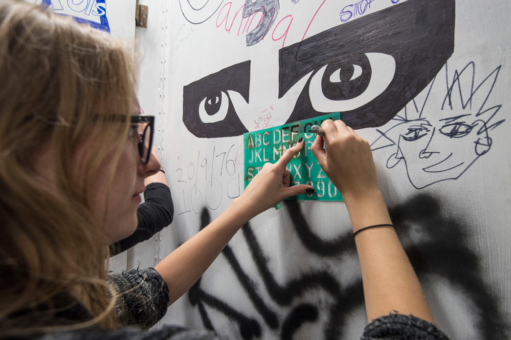 Student from Central Saint Martins decorates display for the Being Punk Show Space.