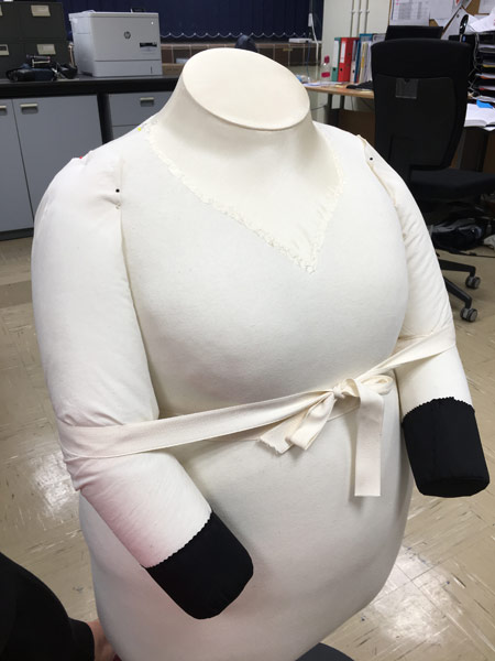 Padded mannequin with silk neck covering and padded arms to display Queen Victoria's mourning dress.