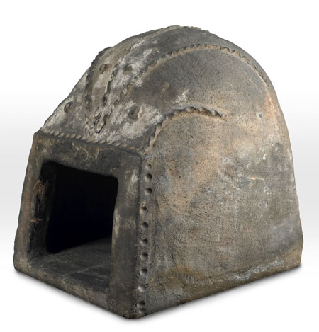 This portable ceramic oven was heated by lighting a fire inside the oven, shuting the door (now missing) and waiting for the oven to reach the right temperature. When it was hot enough, the baker would rake out fire and replace it with the bread, pies or whatever else was to be cooked. To test the temperature the baker spat, or flicked water, onto the oven. They would know how hot the oven was from the type of hiss made when the water evaporated. This oven was probably a portable one taken to fairs on a cart. It was made in North Devon. Ovens like this were also exported to America for 17th-century settlers to use. Thomas Farriner, the owner of the Pudding Lane bakery where the Great Fire of London started, would have had a much larger, brick oven in a similar shape to this one.

