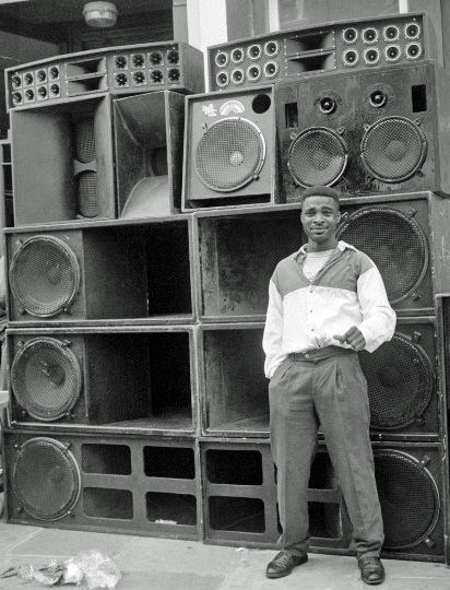 A sound system photographed with a young man standing next to it at the Notting Hill Carnival.